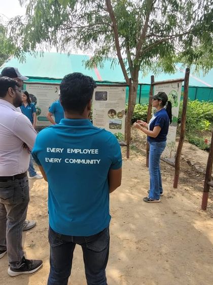 A Valvoline Cummins team member with the words "Every Employee Every Community" on his back listens to our expert at the nursery.