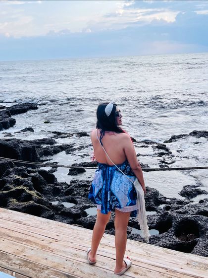 Looking out at the sea in Goa. The backless design of my dress was perfect for the warm weather and added a stylish touch to my beach look.
