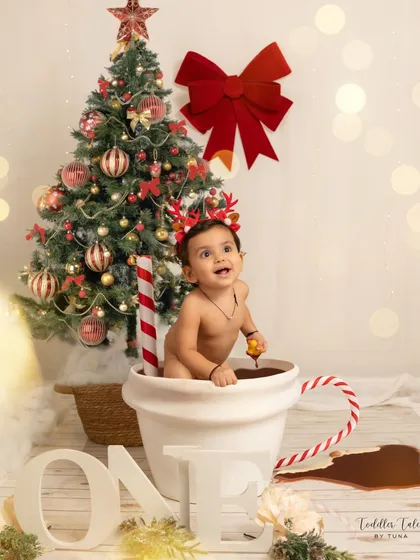 A one-year-old enjoys a creative "hot chocolate" bath session against a festive Christmas backdrop. This shows a glimpse into my fun, themed milestone shoots that turn big moments into playful, unforgettable memories.