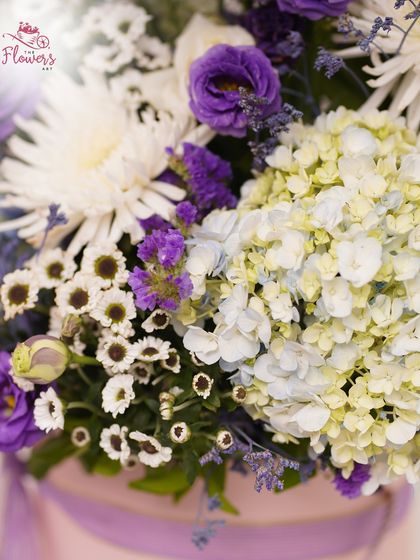 A close-up view highlighting the delicate textures of the flowers. You can see the soft petals of the hydrangea, the intricate layers of the eustoma, and the fresh white chrysanthemums that complete the bouquet.