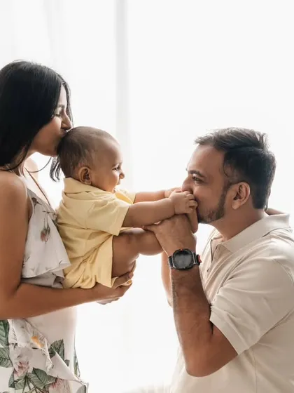A tender moment between father and child. The soft, natural light from the window adds a beautiful, gentle quality to this in-studio family portrait.