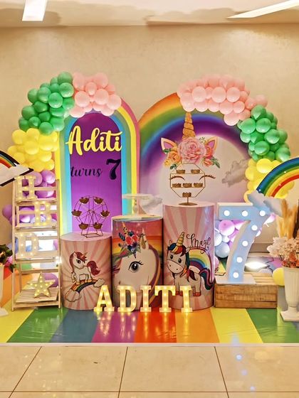 A magical unicorn and rainbow theme for Aditi's 7th birthday. We created a complete fantasy world with a rainbow-striped floor, multiple rainbow arches, unicorn-themed props, and a large light-up number '7'.