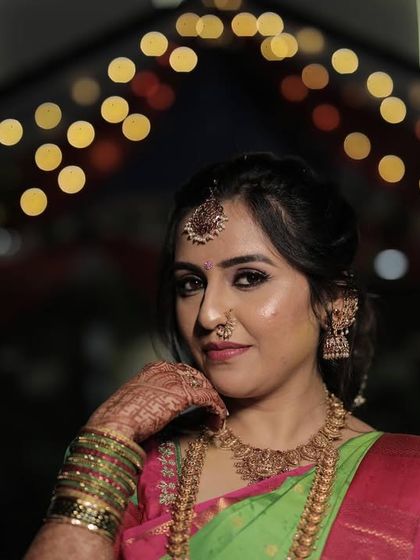 A beautiful nighttime shot of Chinmayi during her varpooje. The makeup looks stunning even in low light, with a focus on radiant skin and expressive eyes.