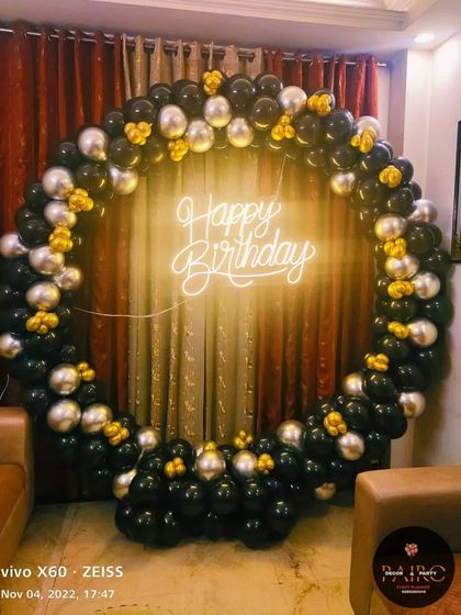 A classic black, silver, and gold balloon ring, a popular and timeless choice for an elegant birthday party at home.