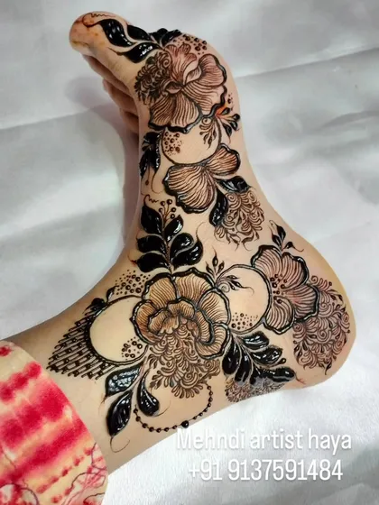 A close-up of the bold floral foot design, highlighting the fine lines and shading that give the flowers a lifelike quality.