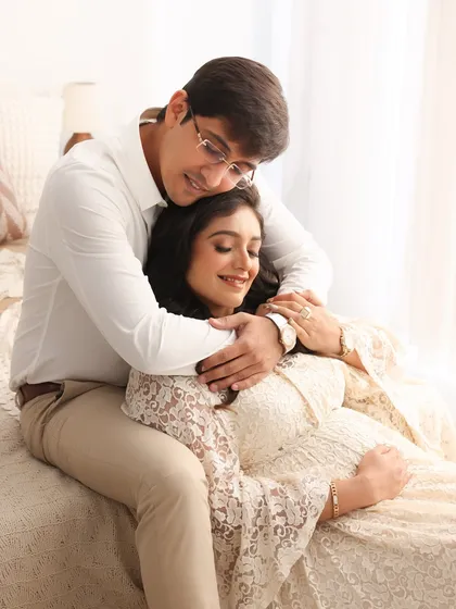 A sweet and tender moment. The gentle way he embraces her from behind shows his love and protection as they cherish this special time.
