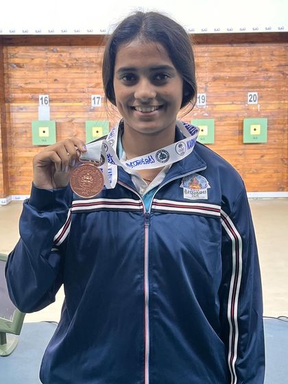 Dvija showing her bronze medal won in the Pistol women ISSF event at the 2nd Nagaraj Rao competition.