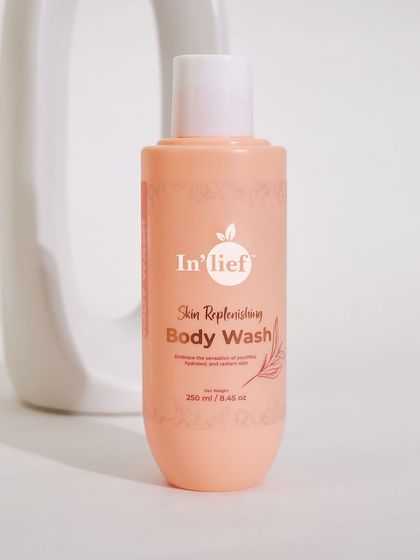A minimalist composition featuring the In'lief body wash with a simple white arch prop. This abstract styling is modern and focuses on the product's shape and design.