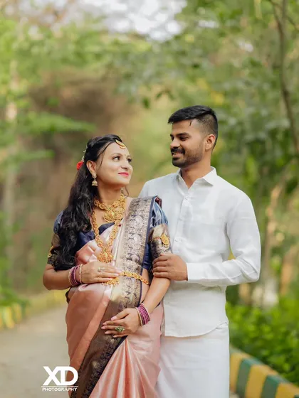 A romantic shot of a couple looking at each other, captured on a quiet, tree-lined path.