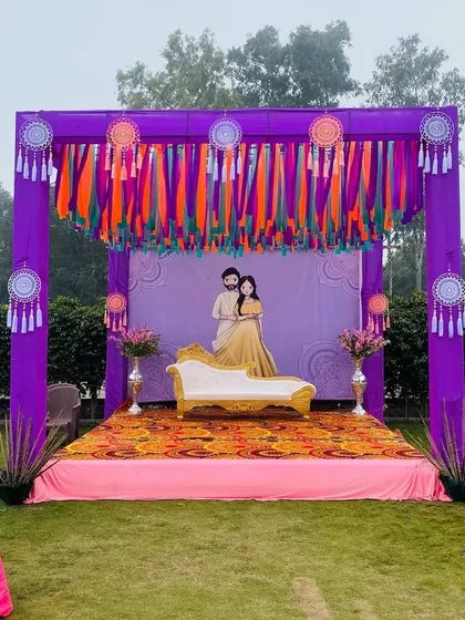 A wider view of the purple outdoor stage, showing how it creates a perfect, colorful photo opportunity in a garden setting.