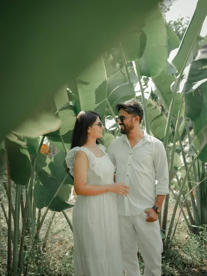 An intimate moment with foreheads touching, framed by the vibrant green leaves of a Pune garden. This shot feels private and serene, perfectly capturing the couple's deep connection.