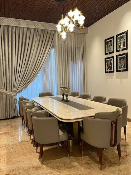 Every detail is considered, from the brass-tipped legs of the chairs to the curated art on the walls, ensuring a cohesive and luxurious dining experience.