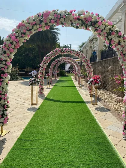 A classic and romantic entranceway for a daytime wedding. We lined the path with a series of beautiful floral arches in pink and white, creating a stunning walkway for the guests and the wedding party.