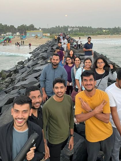 The group walking along the rocky sea promenade in Pondicherry, a popular evening hangout spot.
