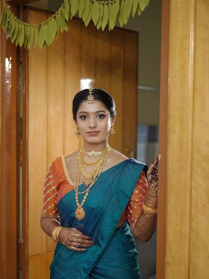 A welcoming pose from the bride. Her makeup is fresh and radiant, designed to make her feel confident as she greets her guests on her special day.