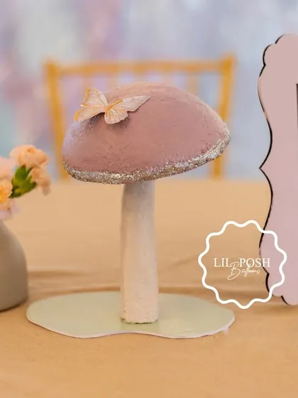 A themed centerpiece featuring a glittery mushroom and a framed photo of the birthday girl.