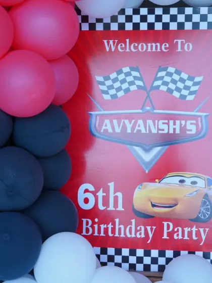 A personalized welcome sign for Avyansh's 6th birthday, featuring Lightning McQueen from 'Cars'. The checkered flag border adds to the racing theme.