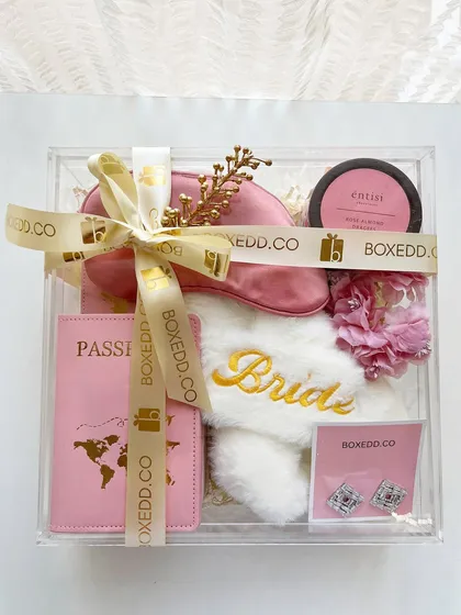 I believe in upgrading from the traditional 'shagun ka lifafa'. This acrylic box for the bride-to-be is filled with honeymoon essentials like a passport cover and comfy slippers.