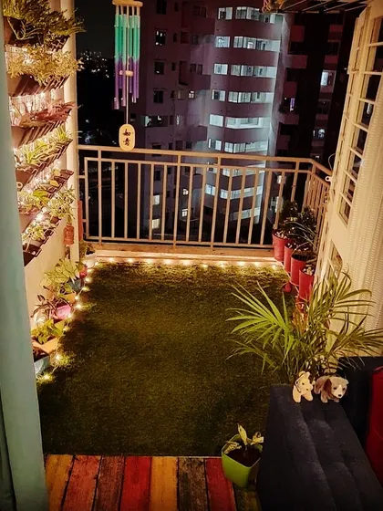 At night, this small balcony transforms into a magical retreat. I installed a vertical wall planter with integrated lighting, artificial grass, and a colorful rustic wood floor detail to create a vibrant and cozy atmosphere.