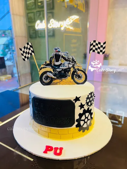 Another great cake for a biker. This design features a different adventure bike model, checkered flags, and gear details, customized for the birthday person.