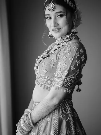A classic black and white bridal portrait. The soft window light and the bride's gentle expression create a timeless, elegant, and soulful image.