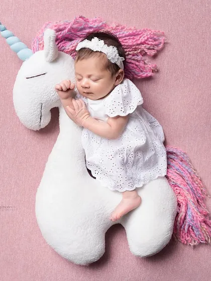Wrapped in unicorn dreams and cozy cuddles. This whimsical setup with a soft unicorn toy is perfect for adding a touch of magic to your newborn's first photoshoot.