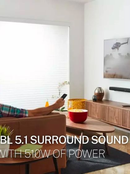 A lifestyle image showing a person enjoying the JBL 5.1 surround sound system. With 510W of total power, it fills the room with dynamic, powerful audio for movies, sports, and games.