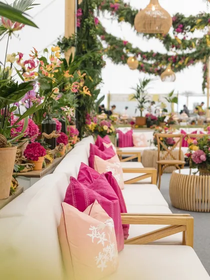 Bright pink cushions add a pop of color to the neutral-toned lounge furniture. We use accent colors strategically to bring energy and personality to our decor schemes.
