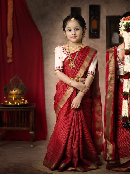 A beautiful girl in a traditional red saree, adorned with a jasmine flower braid. This is a classic portrait celebrating our cultural heritage.