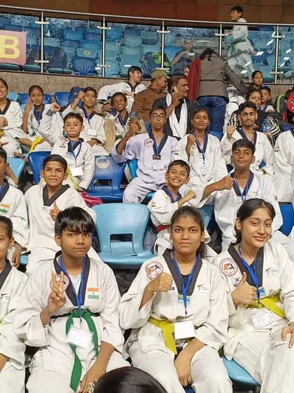 Our students in their doboks, cheering from the stands at the national championship.