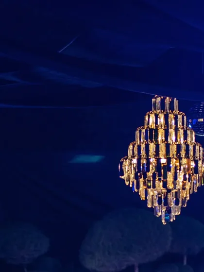 Another detail of the beautiful chandeliers, contrasting warmly against the deep blue draped ceiling.