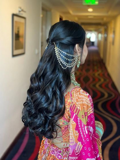 Another view of the classic half-up style with soft curls and a kaan chain. This is a go-to look for its elegance and simplicity.