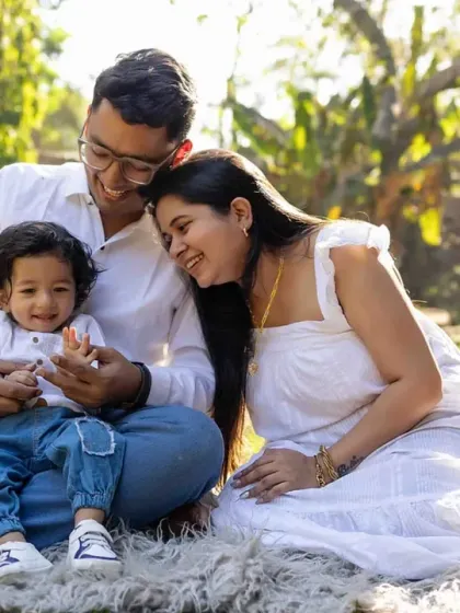 A sweet family cuddle in the park. The golden sunlight adds a magical glow to this loving portrait.