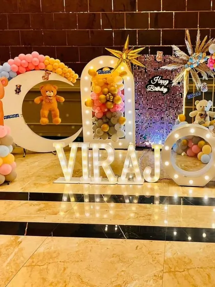 A cute teddy bear-themed birthday party for 'VIRAJ', featuring moon and star cutouts, a sequin backdrop, and marquee letters.