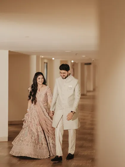 The couple walks hand-in-hand down a brightly lit corridor. This shot captures a sense of journey and partnership, a perfect metaphor for their new life together.