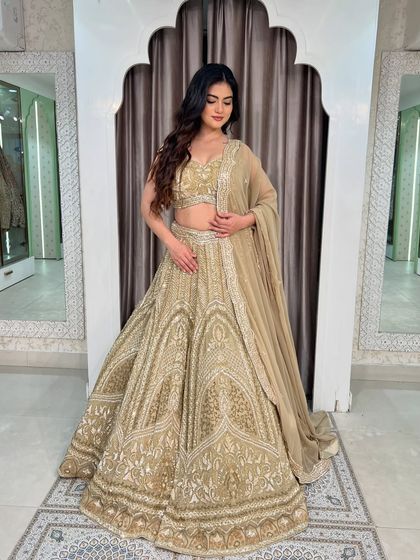 A full-length view of the sparkly golden lehenga, showing its A-line cut and the beautiful way it catches the light.