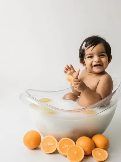 A big, happy smile from the little girl in the orange and lemon fruit bath.