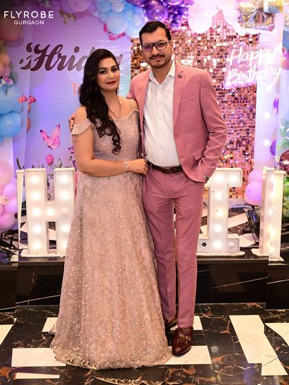 This couple is ready for a party. He stands out in a stylish pink suit, showing that I offer modern and colorful options beyond traditional black-tie attire.