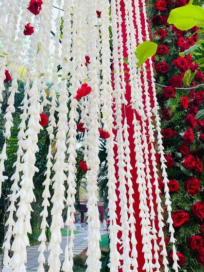 A close-up of the hanging floral strings, a delicate detail that added movement and elegance to the red rose entrance.
