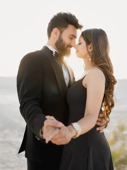 A romantic dance at sunset in the desert. The warm backlighting creates a beautiful halo effect around the couple, enhancing the intimacy of the moment.