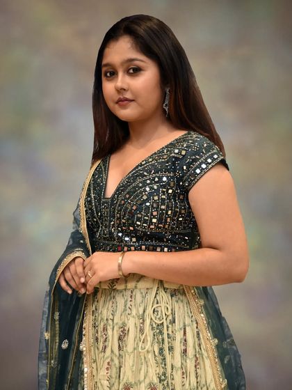 A close-up on the intricately detailed bottle green blouse, showcasing the beautiful mirror work that adds a touch of sparkle and traditional craft.