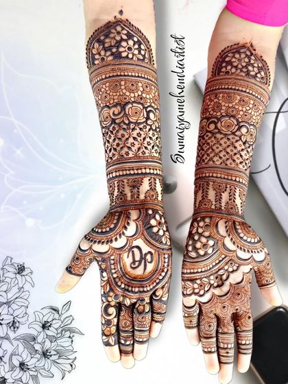 A beautiful engagement henna design with full arm coverage. The pattern includes the couple's initials, 'DP', inside a lovely motif on the palm.
