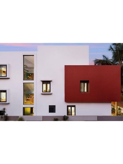 The street-facing facade of the "Solid | Void | Solid House" is a composition of solid white and red volumes, punctuated by carefully placed windows.