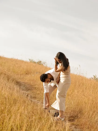 A candid and playful moment in the hills, showing the groom helping his bride with her shoe. It's the small, real moments that count.