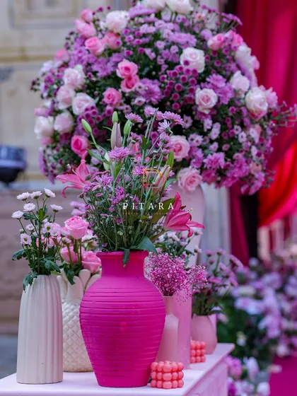This statement console table is all about modern romance. We used a variety of textured pink and white vases, filled with roses and chrysanthemums, and accented them with bubble candles for a chic, layered look.