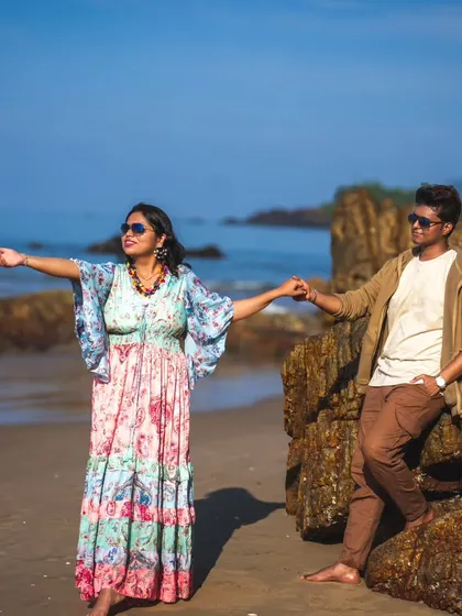 A candid walking shot on the beach, with the couple holding hands. The natural movement and beautiful coastal background make this a lovely, dynamic pre-wedding picture.