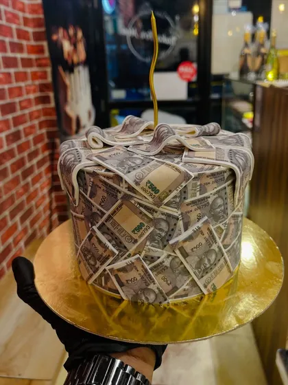 A fun cake covered in edible 500 rupee notes, perfect for a birthday celebration.