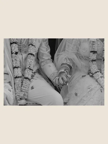 A black and white detail shot of the couple holding hands during the ceremony. This simple yet powerful image symbolizes their unity and the promises they are making to each other.