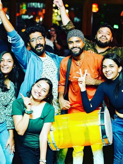 Posing with a dhol player and happy partygoers at Badmaash. I often collaborate with live musicians to enhance the energy of my sets.