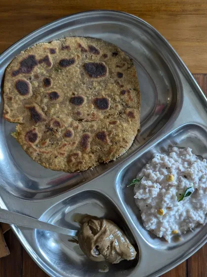 A healthy and complete meal on my plate. This features a multi-grain paratha with peanut curd rice and a side of almond butter, showing how you can balance your meals holistically.